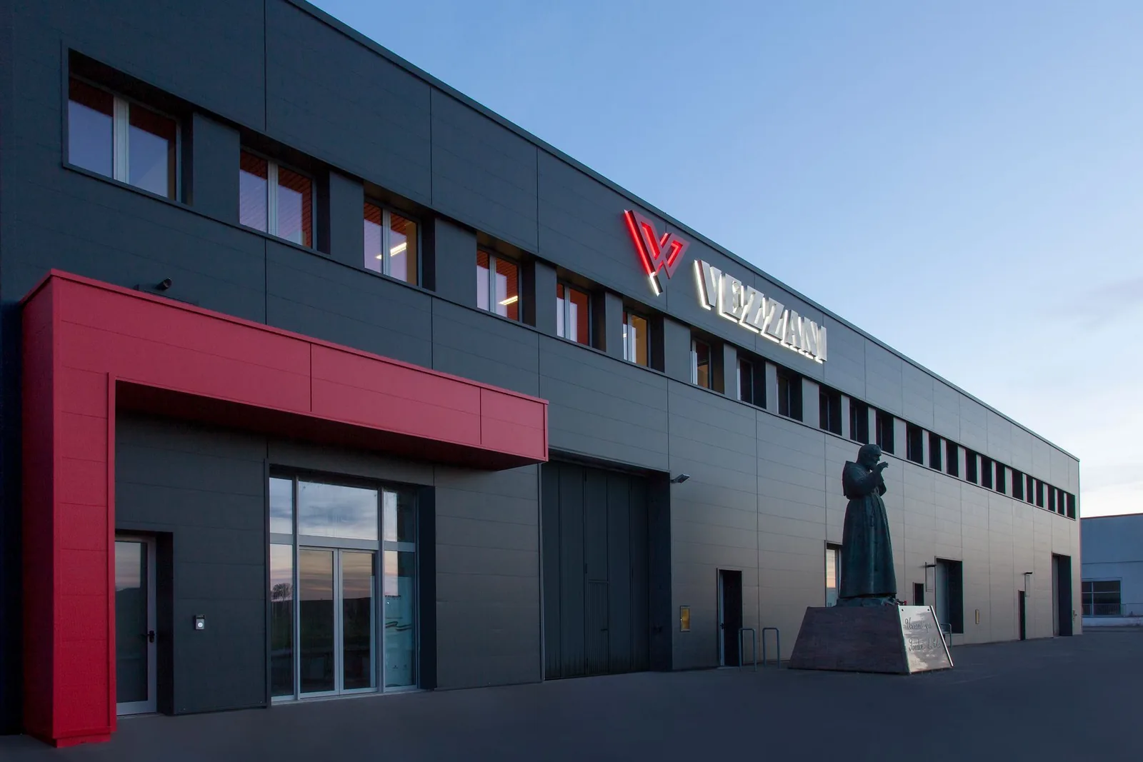 The Vezzani Group headquarters at dusk, with the illuminated sign